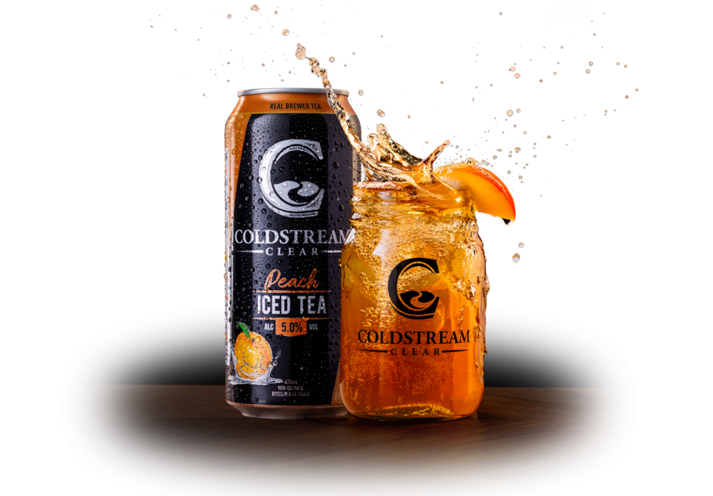 Coldstream Clear Peach Iced tea served on the rocks in a mason jar with a peach garnish